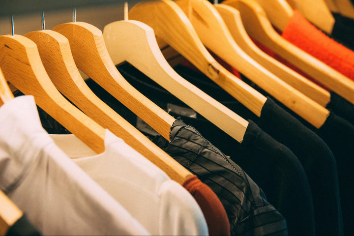 close up of hangers on a rack with clothes